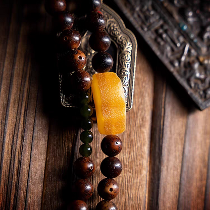 Wooden beaded necklace with a yellow pendant on a wooden surface