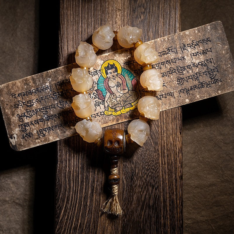 Mala with yak horn beads and a Tara icon on a wooden background