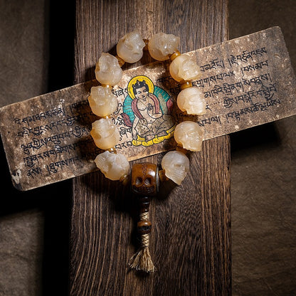 Mala with yak horn beads and a Tara icon on a wooden background