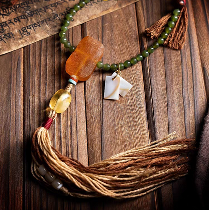 Necklace with beads and tassel on a wooden surface